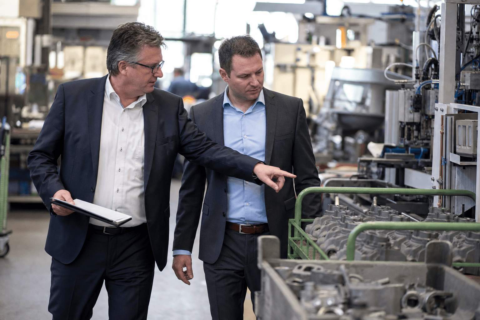 Zwei Führungskräfte begehen den Wertstrom in der Fertigung und markieren einen Engpass