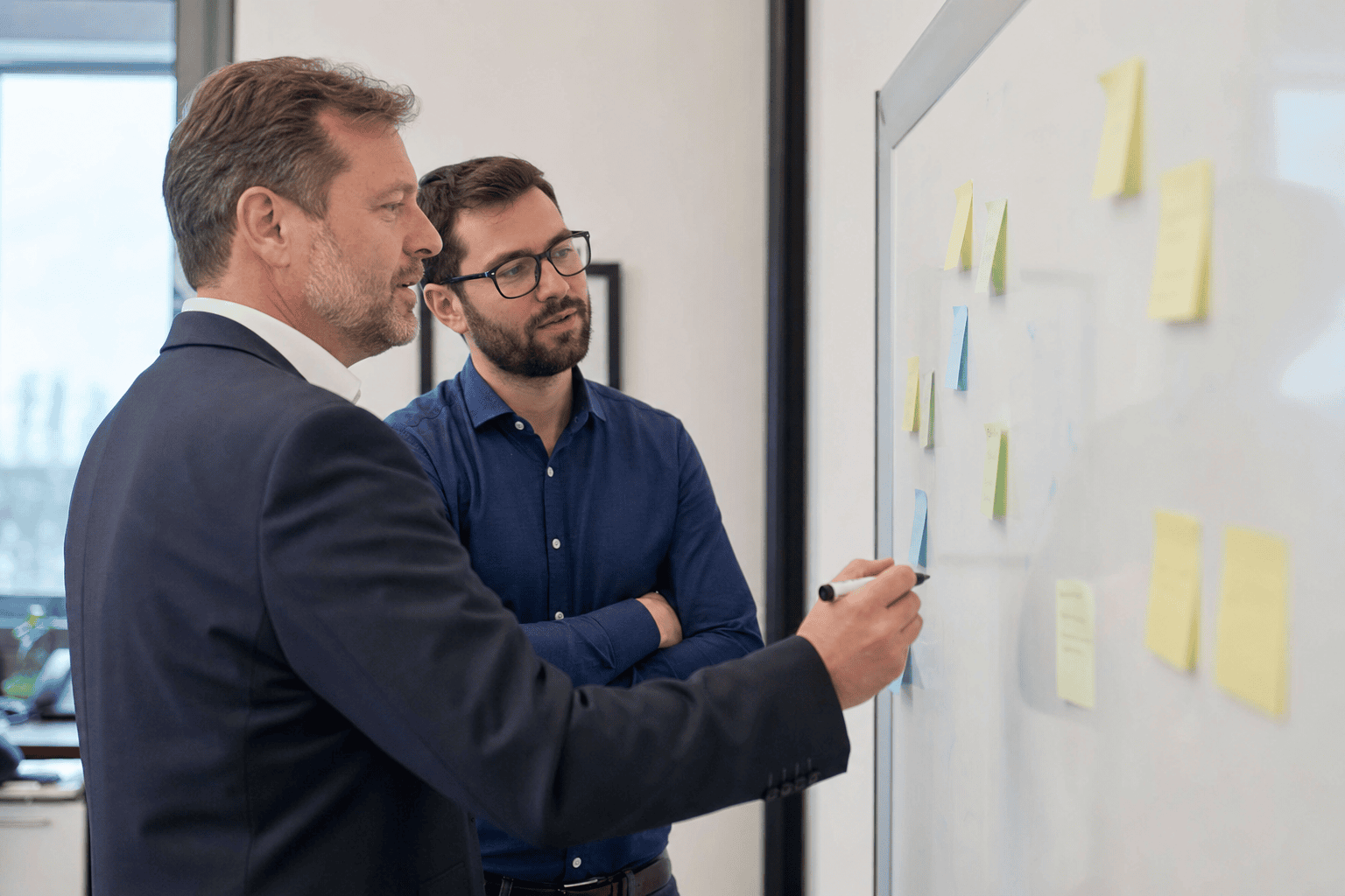 Geschäftsführung und IT-Leitung ordnen Tätigkeiten am Whiteboard in Stufen ein
